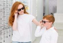 smiling sibling with black eyeglasses posing optics store 23 2148241480