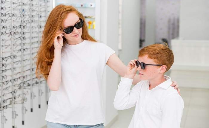 smiling sibling with black eyeglasses posing optics store 23 2148241480