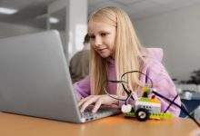 young girl using laptop electronic parts build robot 23 2149357689