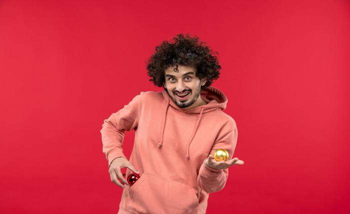 front view young man smiling with christmas toys red wall 140725 55685