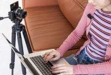 high view blogger sitting couch using her laptop