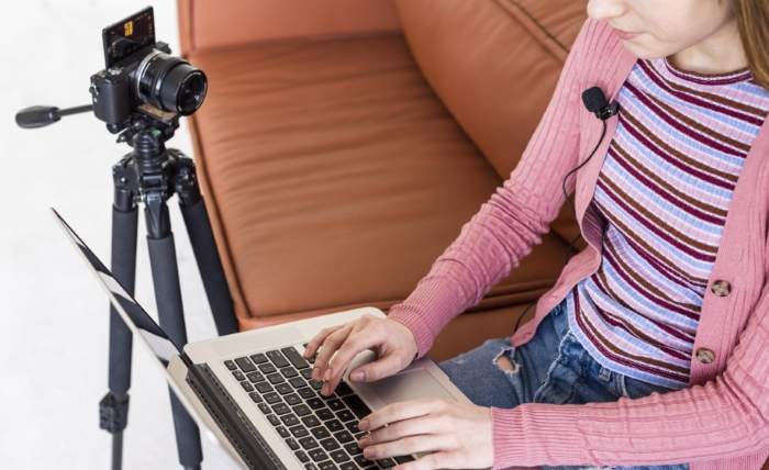 high view blogger sitting couch using her laptop