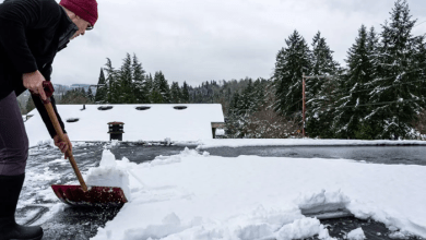 flat roofer clearing snow